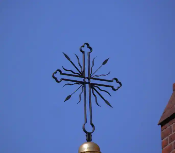 Cross with wavy lines and arrows on top of a steeple